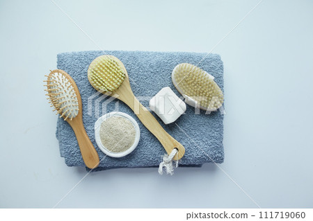 Clean towels, massage brush and bar of soap on table . Clean towels, massage brush and bar of soap on table . 111719060
