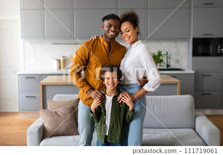 Happy black family with child smiling together in the kitchen 111719061