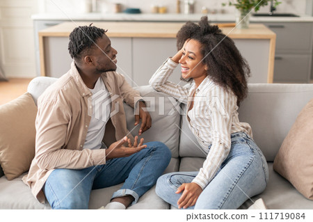 Happy African American Couple Talking Sitting On Sofa At Home Happy African American Couple Talking Sitting On Sofa At Home 111719084