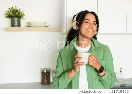 Happy African American Lady Wearing Headphones Holding Coffee Cup Indoor 111719152