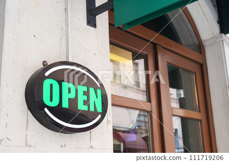 Open sign hanging front of cafe . 111719206