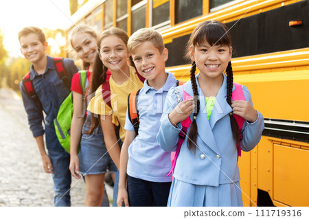 Portrait Of Happy Schoolchildren Posing Near Yellow School Bus 111719316
