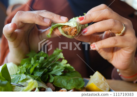 women eating Raw meatballs or cig kofte. Traditional Turkish cuisine delicacies. 111719383