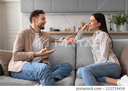 Happy spouses chatting on the couch at home 111719456
