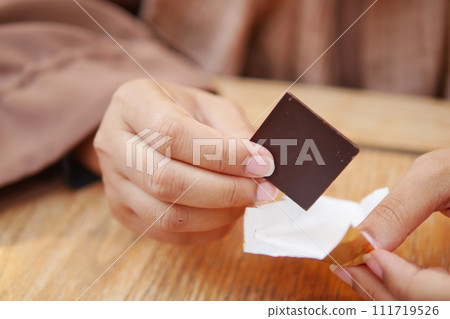 women holding a dark chocolate  111719526