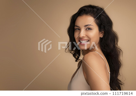 Beautiful brunette long-haired young indian woman posing on beige 111719614