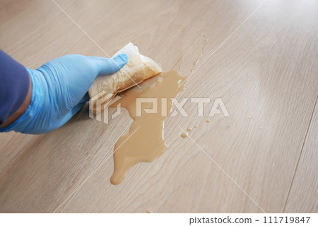 A man's hand washing the floor with a tissue A man's hand washing the floor with a tissue 111719847