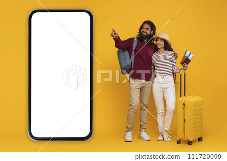 Indian couple tourists pointing at big phone Indian couple tourists pointing at big phone 111720099