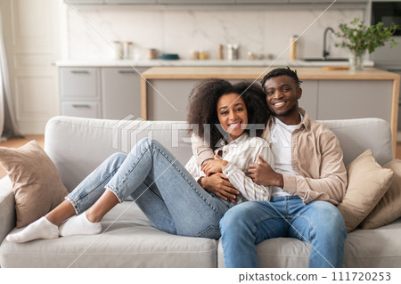 Romantic African Couple Hugging While Chilling On Couch At Home Romantic African Couple Hugging While Chilling On Couch At Home 111720253