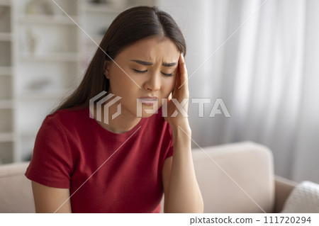 Asian woman with severe headache feeling unwell at home Asian woman with severe headache feeling unwell at home 111720294