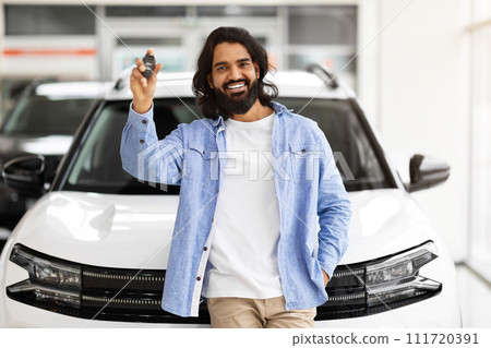 Excited millennial indian guy standing next to new car 111720391