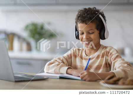 Online Lesson. Black Boy In Wireless Headphones Study With Laptop At Home Online Lesson. Black Boy In Wireless Headphones Study With Laptop At Home 111720472