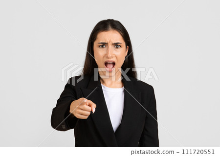 Angry european businesswoman pointing forward with stern expression Angry european businesswoman pointing forward with stern expression 111720551