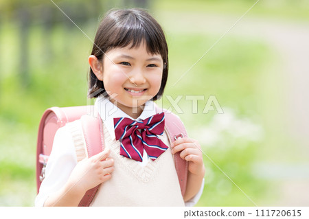A girl carrying a school bag A girl carrying a school bag 111720615