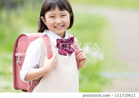 A girl carrying a school bag 111720621