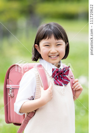A girl carrying a school bag 111720622