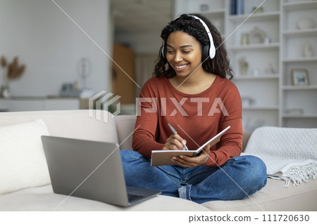 Young Black Woman In Headphones Study Online With Laptop From Home Young Black Woman In Headphones Study Online With Laptop From Home 111720630