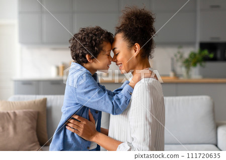 Loving mother and son sharing tender nose-to-nose embrace, side view 111720635