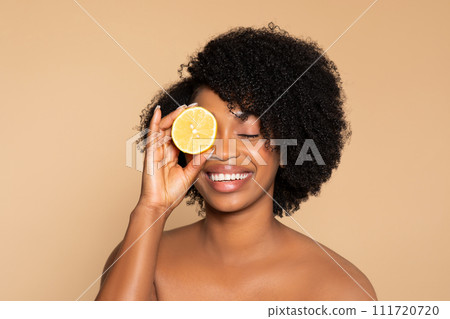 Joyful black woman with lemon, natural beauty theme Joyful black woman with lemon, natural beauty theme 111720720