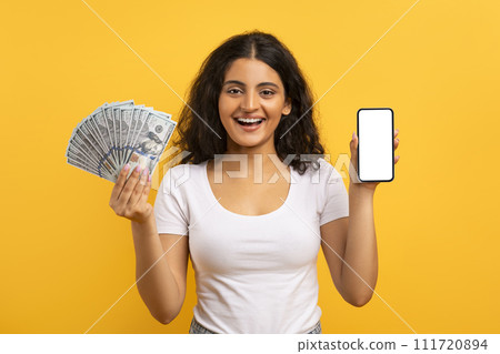 Cheerful young indian lady showing phone and money 111720894
