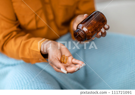 A close-up image capturing a woman in an orange shirt pouring clear A close-up image capturing a woman in an orange shirt pouring clear 111721091