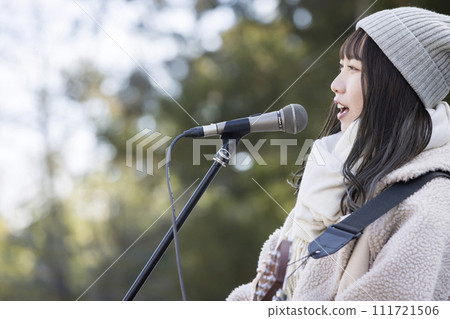 冬天,一位年輕女子在街頭唱歌、玩耍。 冬天,一位年輕女子在街頭唱歌、玩耍。 111721506