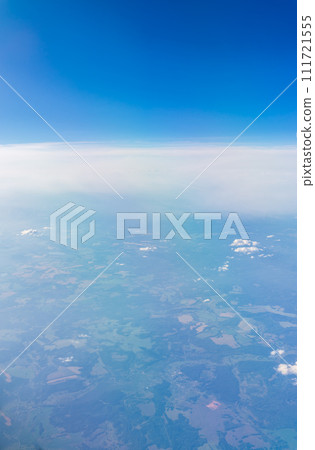 View from the airplane window at a beautiful cloudy sky and the airplane wing 111721555