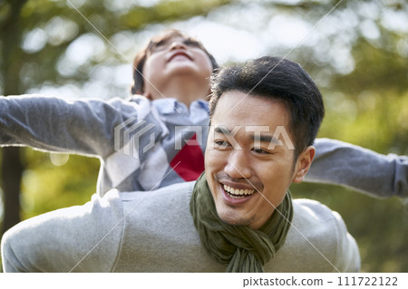 asian father and son having fun outdoors in park asian father and son having fun outdoors in park 111722122