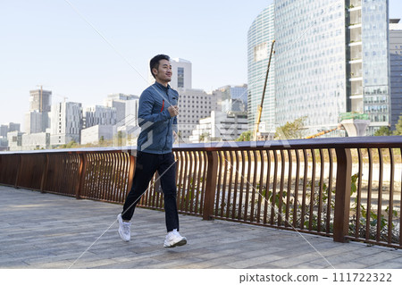 young asian man jogging exercising outdoors on riverfront path young asian man jogging exercising outdoors on riverfront path 111722322