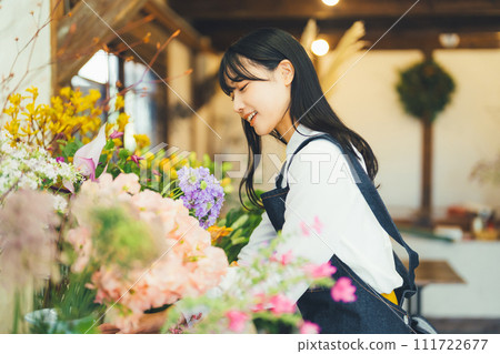 Female staff at a flower shop Female staff at a flower shop 111722677