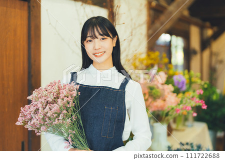 Female staff at a flower shop Female staff at a flower shop 111722688