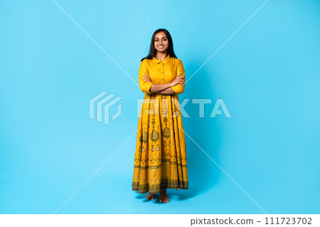 Smiling hindu lady wearing dress posing with folded arms, studio Smiling hindu lady wearing dress posing with folded arms, studio 111723702