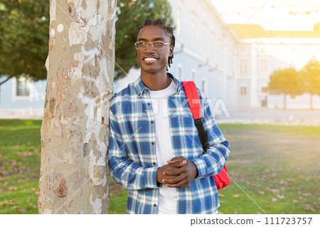 Black university student guy holds backpack standing on campus outside 111723757