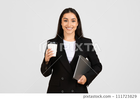Smiling young businesswoman with coffee and laptop 111723829