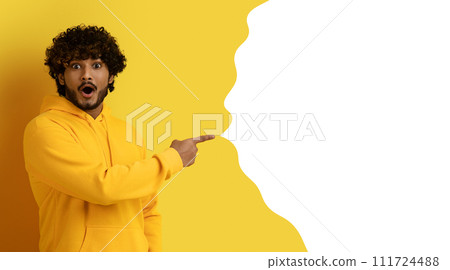Excited indian guy pointing at free space on yellow backdrop Excited indian guy pointing at free space on yellow backdrop 111724488