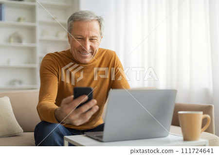 Senior businessman working from home, using laptop and smartphone Senior businessman working from home, using laptop and smartphone 111724641