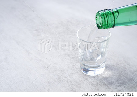 Pour Korean soju into a glass 111724821