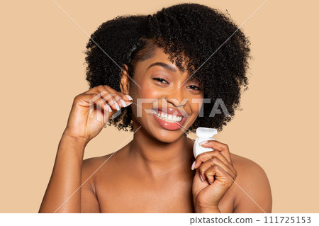 Happy african american woman flossing her teeth with bright smile Happy african american woman flossing her teeth with bright smile 111725153