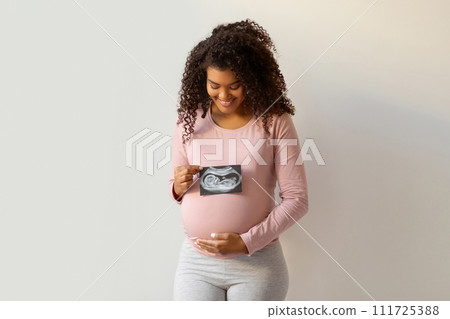 Maternity Concept. Happy Black Pregnant Woman Holding Ultrasound Photo Of Her Baby Maternity Concept. Happy Black Pregnant Woman Holding Ultrasound Photo Of Her Baby 111725388