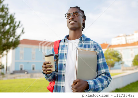 Cheerful Black Guy Student Posing With Laptop And Workbooks Outside Cheerful Black Guy Student Posing With Laptop And Workbooks Outside 111725452