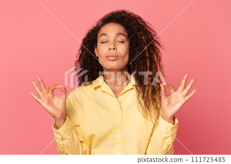 Relaxed african american woman doing yoga gesture Relaxed african american woman doing yoga gesture 111725485