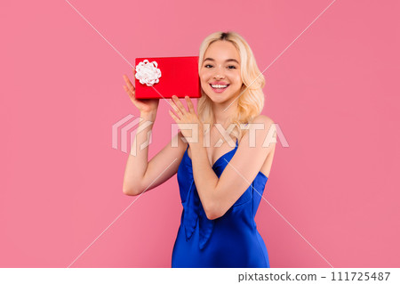 Happy blonde woman with gift box, joyful surprise gesture Happy blonde woman with gift box, joyful surprise gesture 111725487