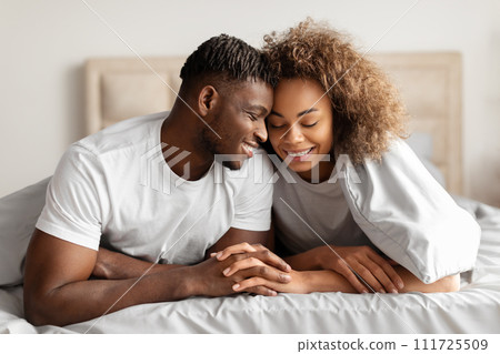Happy Black Lovers Couple In Bed Holding Hands Touching Foreheads Happy Black Lovers Couple In Bed Holding Hands Touching Foreheads 111725509