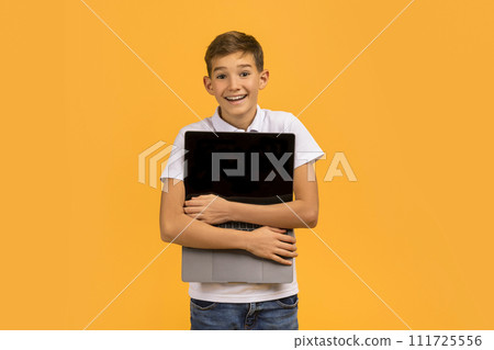Tech Lover Concept. Cheerful Teen Boy Hugging Laptop With Blank Screen Tech Lover Concept. Cheerful Teen Boy Hugging Laptop With Blank Screen 111725556