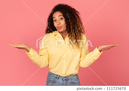 Indecisive black woman weighing options on pink backdrop 111725678