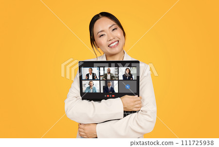 A content woman in a business suit hugs her laptop, which displays a virtual business 111725938