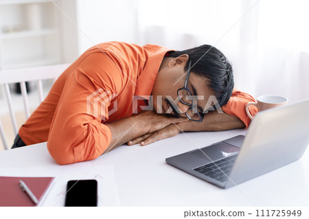 Tired middle aged indian man sleeping at working place 111725949