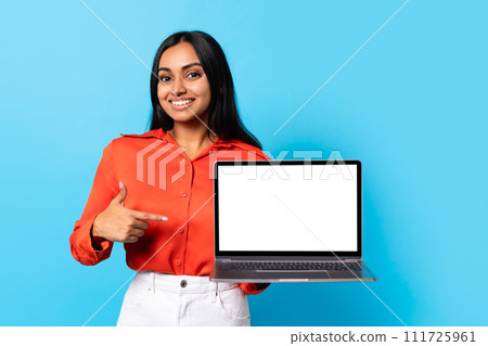 Middle Eastern lady pointing finger at empty computer screen, studio Middle Eastern lady pointing finger at empty computer screen, studio 111725961