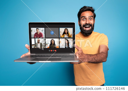 Excited indian man showing laptop with video call screen Excited indian man showing laptop with video call screen 111726146