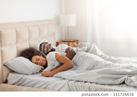 Calm african american husband hugging wife while sleeping together indoors 111726638